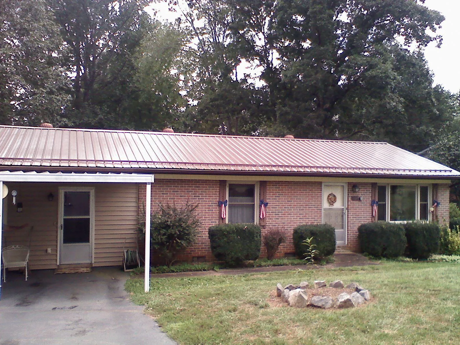 Bronze metal roof and carport on a brick ranch home — Roof Repair work by our crew in Hodges