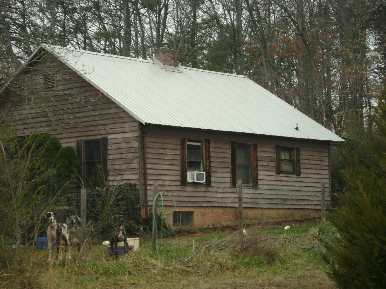 White metal roof on an old wood sided farmhouse, from a Metal Roof Installation job in Hodges